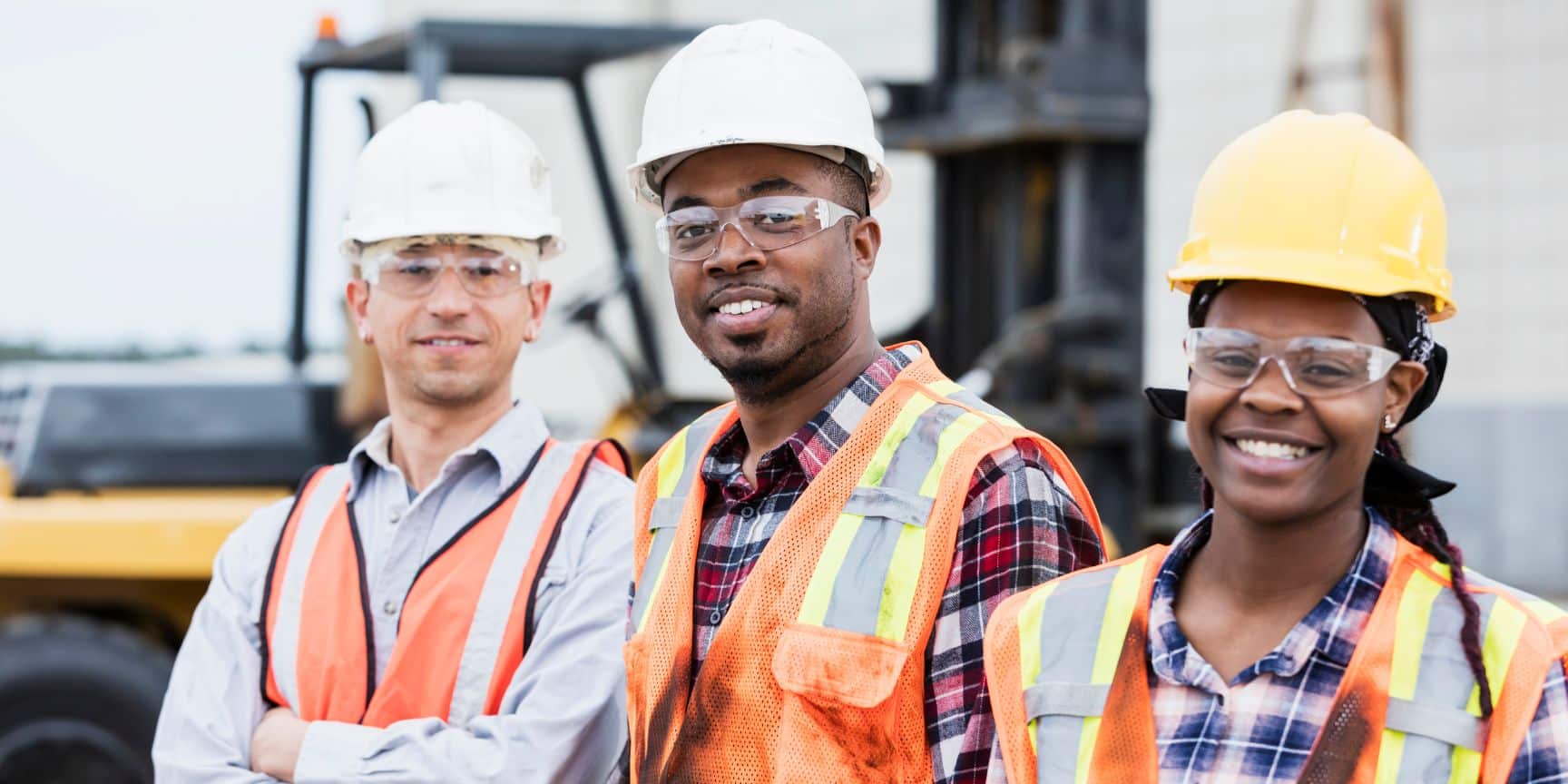 Industrial workers smiling wearing hard hats